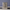 Cross of Salvation Brass Memorial Urn on a small stone pedestal with a charcoal runner against a bluish-purple wall